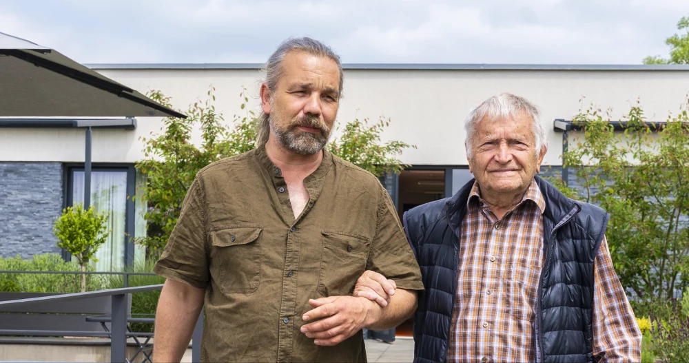 Fotografie pečovatele pomáhajícího seniorovi